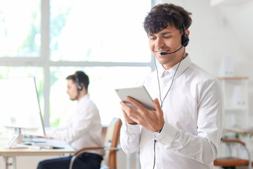 Wall Mural - Male technical support agent with tablet computer in office