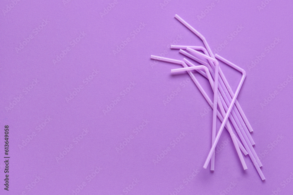 Lilac plastic straws on purple background