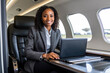 © OpticalDesign - African american businesswoman in private jet, laptop, boss, entrepreneur, ceo, luxury jet, remote work, diversity, millionaire, success