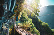 © Michael - Tourist woman walking below big rock wall along water canal at steep cliff through Madeiran rainforest. Levada of Caldeirão Verde, Madeira Island, Portugal, Europe.