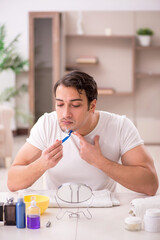 Wall Mural - Young man shaving face at home