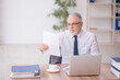 © Elnur - Old male employee working in the office