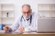 © Elnur - Old male doctor radiologist working in the clinic