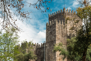 Wall Mural - Guimaraes, Portugal. April 14, 2022: Walls and structures of Guimarães castle with blue sky.