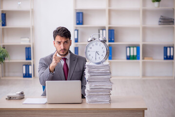 Wall Mural - Young male employee in time management concept