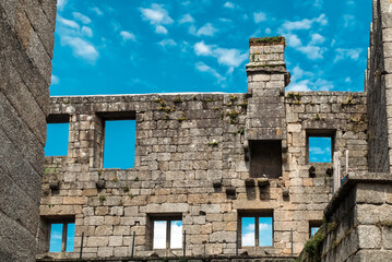 Wall Mural - Guimaraes, Portugal. April 14, 2022: Walls and structures of Guimarães castle with blue sky.