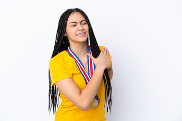 Wall Mural - Teenager girl with braids and medals over isolated pink background suffering from pain in shoulder for having made an effort