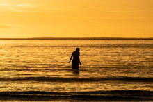 Silhouette Of Female Swimmer Going Into The Atlantic Ocean In Ireland