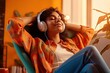 © ttonaorh - Young woman in headphones listening to music at home. Girl sitting on  sofa