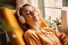 Young Woman In Headphones Listening To Music At Home. Girl Sitting On  Sofa