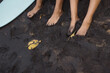 Foots of couple in love sitting on black sand after surfing. Beach travel in Sri Lanka