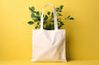 Mock up for design of white canvas shopper bag with green plant leaves isolated on flat yellow background with copy space. Eco-friendly plastic free bag template. Generative AI 3d render.