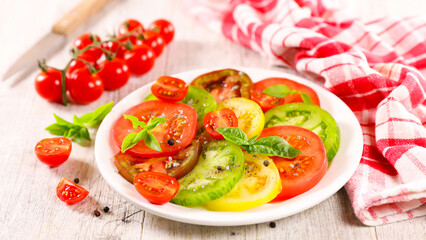 Wall Mural - slices tomatoes salad with basil leaves