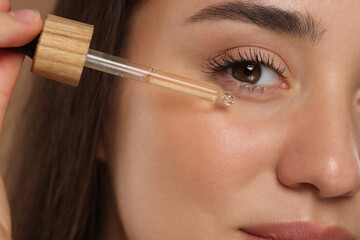 Wall Mural - Woman applying essential oil onto face, closeup