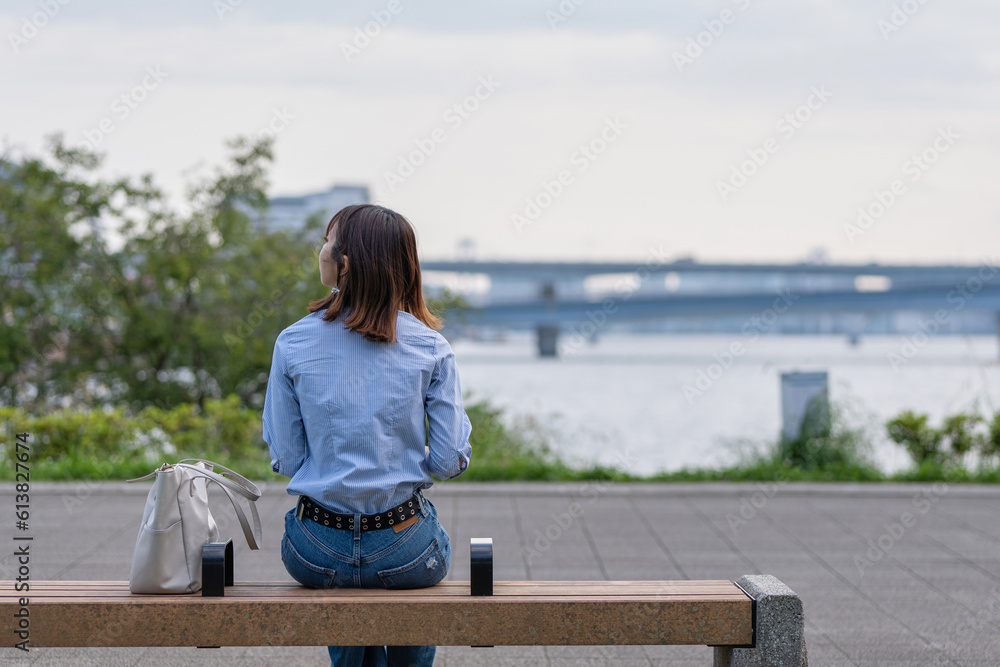 海の近くの公園のベンチに座る女性の後ろ姿 の Stock フォト | Adobe Stock