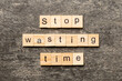 Stop wasting time word written on wood block. Stop wasting time text on cement table for your desing, Top view concept
