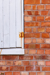 Red old brick wall with part of shutter