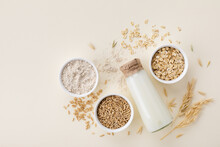 Oat Milk, Flour, Dry Flakes And Whole Grains Top View. Set From Organic Oat Products For Vegetarian And Healthy Food.
