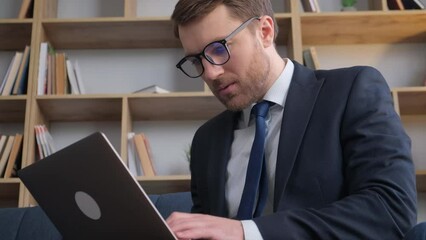 Young focused financial worker software developer working on laptop. 