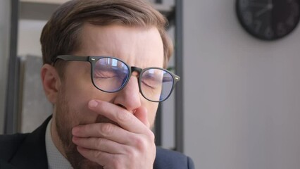 close-up of face of sleepy office worker, project manager. a young tired worker yawns.