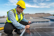 Asian engineer inspecting installation of solar panels installed on factory roof, technician, foreman calculates design on tablet. Engineer to supervise the solar panel installation project