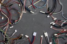 Colored Cables And Wires With Connectors On Gray Concrete Background. Colorful Different Computer And Other Wires. Telecommunications. Blank For Postcard With Space For Text. Flatlay