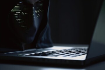 Close-up of a hacker using a laptop in a dark room. Generative AI
