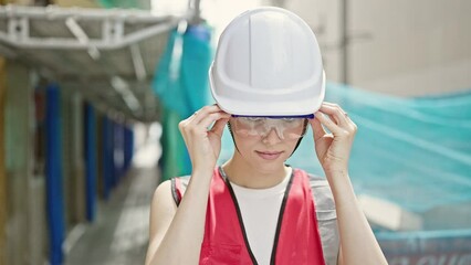 Wall Mural - Young beautiful hispanic woman builder smiling confident wearing glasses at street