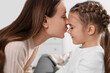 © New Africa - Happy mother kissing her cute daughter indoors, closeup