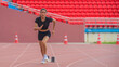 © Mongkolchon - Asian female athlete accelerates during her speed running practice on the stadium track, embodying determination