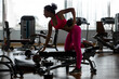 Fitness gym woman strength training lifting dumbbell weights in Bent-over One-Arm Dumbbell Row. Female fitness girl exercising indoor in fitness center. .