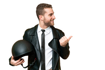 Wall Mural - Business man with a motorcycle helmet over isolated chroma key background pointing to the side to present a product