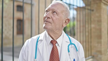 Sticker - Senior grey-haired man doctor standing with doubt expression thinking at street