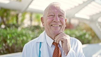 Poster - Senior grey-haired man doctor smiling confident standing at park