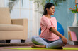 © WESTOCK - Active indian pregnant woman doing exercise or workout on yoga mat at home - concept of healthy lifestyle, fitness and motherhood preparation
