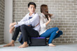 © themorningglory - Happy couple sitting onluggage in new room moving to a new home