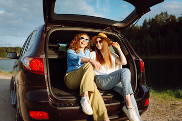 Wall Mural - Two Young woman takes a selfie in the car during a road trip. Lifestyle, travel, tourism, nature, active life.