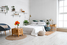Interior Of Stylish Bedroom With Tulip Flowers In Vase On Wooden Table