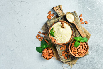 Wall Mural - Wooden spoon with almond flour and nuts. On a concrete background. Top view. Copy space.