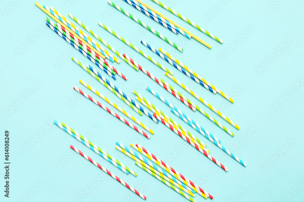 Different paper drinking straws on blue background