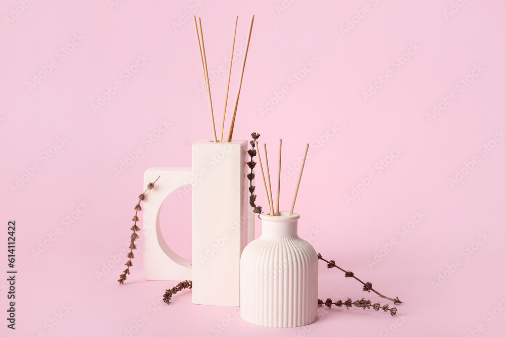Bottles of floral reed diffuser on pink background