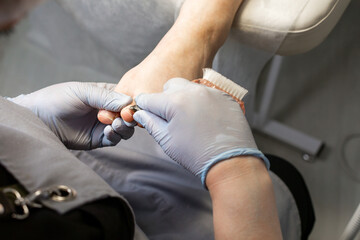 Wall Mural - A close-up of the process of making a pedicure by a master. Nail treatment of the foot.