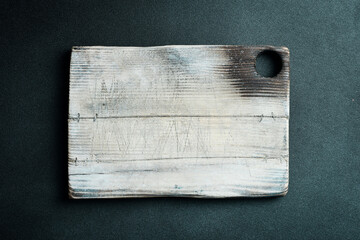 Wall Mural - Empty vintage cutting board on dark wooden planks food background concept.