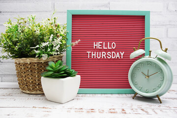 Canvas Print - Hello Thursday text on Letter Board with alarm clcok and artificial plant decoration