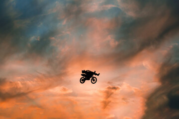 Wall Mural - FMX rider performs dangerous stunts at sunset. Motocross.