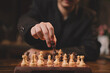 © Atthapon - Close up hand Chess business concept. Businessman moving chess piece on chess board game for ideas and competition and strategy, business success concept, business competition concept.