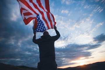 Wall Mural - Man holding a waving american USA flag.