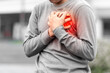 Man covering his heart painfully outdoors, concept of sudden heart attack. 