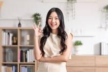 Beautiful Young Asian Woman Showing Thumbs Up OK Gesture Smile With Positive Emotional At Home. Attractive Female Making Okay Hand Sign Or Say Yes Happiness And Cheerful. Women Lifestyle Concept