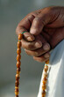 hand holding a misbaha rosary for religious reading, dhikr and remembrance

